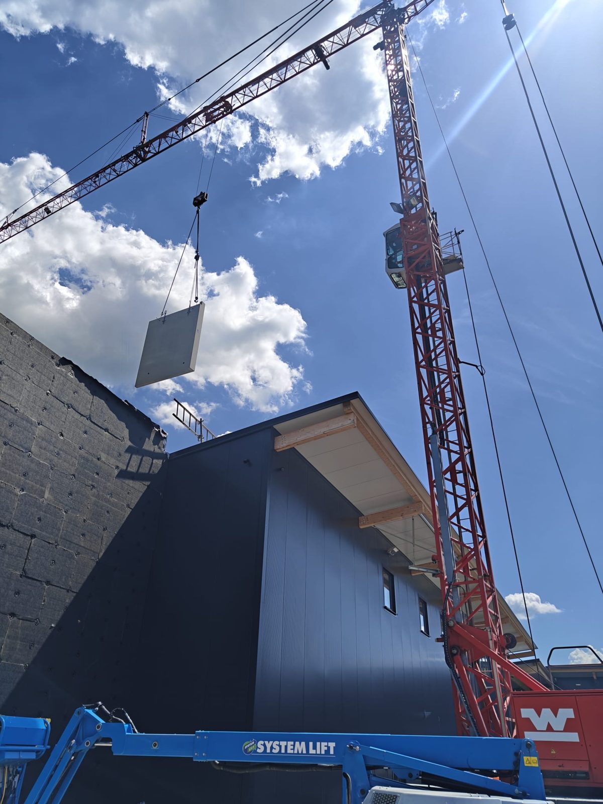 Autokran hebt eine Beton-Vorsatzschale für die Fassadenmontage in Eibelstadt
