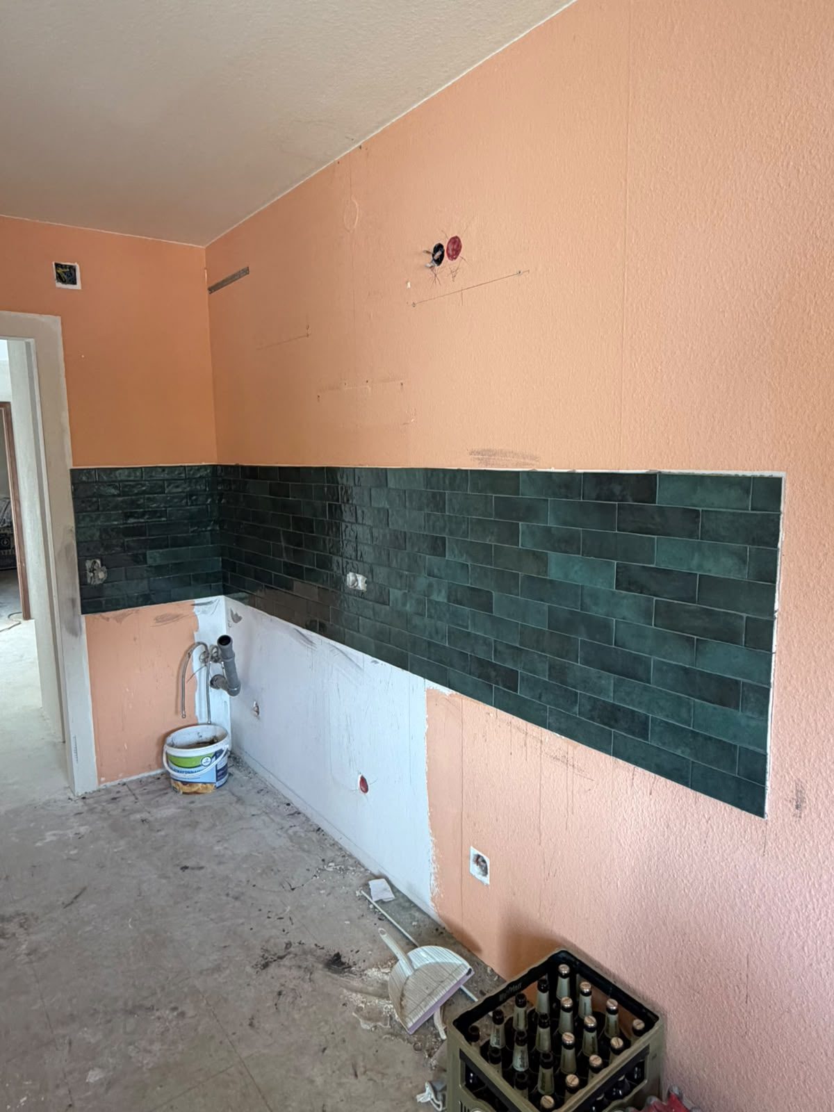 Fliesenarbeiten an der Küchenwand während der Wohnungssanierung