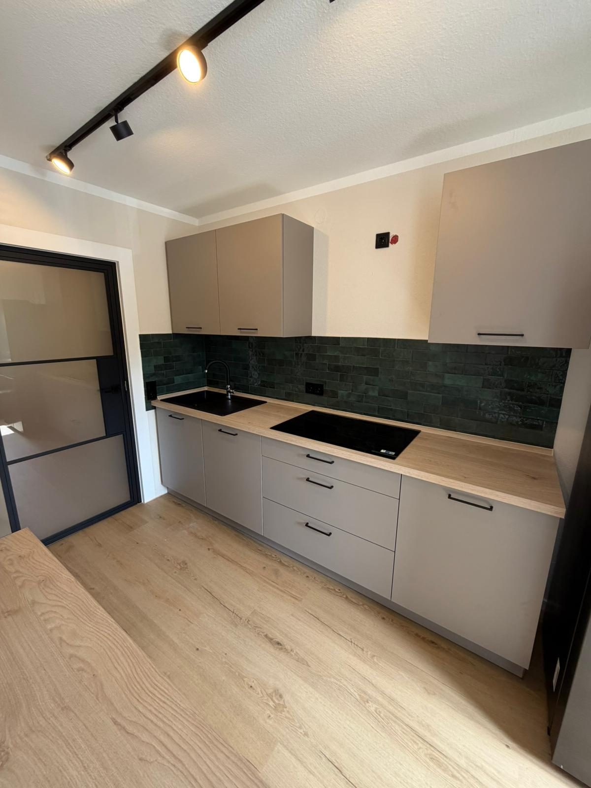 Küche mit grüner Fliesenwand nach der Wohnungssanierung
